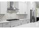 Kitchen with stainless steel appliances, quartz countertops, white cabinets, and mosaic backsplash at 3605 W Dale Ave, Tampa, FL 33609