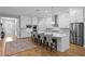 Open-concept kitchen featuring a large island, stainless steel appliances, and hardwood flooring at 3605 W Dale Ave, Tampa, FL 33609