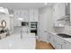 Bright kitchen features white cabinets, stainless steel appliances, quartz countertops, and designer backsplash at 3605 W Dale Ave, Tampa, FL 33609