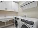 Functional laundry room with white cabinets, sink, and modern washer and dryer at 3605 W Dale Ave, Tampa, FL 33609