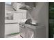 Close-up of outdoor kitchen with stainless steel grill, hood, and sink on screened lanai with white fence at 3605 W Dale Ave, Tampa, FL 33609