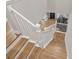This is a staircase with hard wood steps and white risers, a white banister, and hard wood floors at 3605 W Dale Ave, Tampa, FL 33609