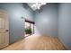Bedroom with blue walls, high ceiling, wood floors, and sliding glass doors to courtyard at 3687 Imperial Ridge Pkwy, Palm Harbor, FL 34684