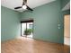 Bedroom with green walls, high ceiling, wood floors, and sliding glass doors to courtyard at 3687 Imperial Ridge Pkwy, Palm Harbor, FL 34684