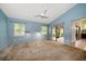Comfortable bedroom features plush carpeting, a ceiling fan, and sliding glass door to private screened patio at 3687 Imperial Ridge Pkwy, Palm Harbor, FL 34684