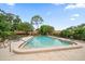 Inviting community pool with ample lounge chairs for relaxation, surrounded by lush trees at 3687 Imperial Ridge Pkwy, Palm Harbor, FL 34684