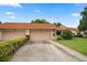 Charming single-story home with a well-manicured lawn, two-car garage, and a terracotta roof at 3687 Imperial Ridge Pkwy, Palm Harbor, FL 34684