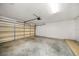 An empty garage with a partially closed garage door, cement floor, and white walls at 3687 Imperial Ridge Pkwy, Palm Harbor, FL 34684