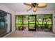Inviting screened patio with a ceiling fan, tiled floor, and views of lush greenery for peaceful enjoyment at 3687 Imperial Ridge Pkwy, Palm Harbor, FL 34684