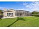 Spacious backyard with a screened-in pool, comfortable patio seating, and a meticulously maintained lawn at 3707 Smoke Hickory Ln, Valrico, FL 33596