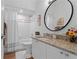 Cozy bathroom featuring a shower-tub combo, granite countertop vanity, and round mirror for a stylish touch at 3707 Smoke Hickory Ln, Valrico, FL 33596