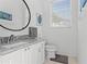 Elegant bathroom with a granite countertop, modern sink, and a large round mirror at 3707 Smoke Hickory Ln, Valrico, FL 33596