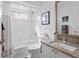 Bright bathroom featuring a bathtub with shower, granite countertop, and stylish decor at 3707 Smoke Hickory Ln, Valrico, FL 33596
