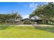 Rear view of the clubhouse showing the screened in porch and landscaped yard with mature trees at 3707 Smoke Hickory Ln, Valrico, FL 33596