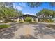 Beautiful view of clubhouse entrance with stone pillars, mature trees, and well-manicured landscaping at 3707 Smoke Hickory Ln, Valrico, FL 33596
