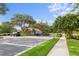 View of the community guard house and entrance, cars parked alongside of building, sidewalk, mature trees at 3707 Smoke Hickory Ln, Valrico, FL 33596