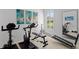 Home gym featuring stationary bikes, weight machines, and a wall mirror for a complete workout experience at 3707 Smoke Hickory Ln, Valrico, FL 33596