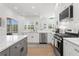 Well-lit kitchen offers stainless appliances, sleek white cabinetry, and views of the pool area at 3707 Smoke Hickory Ln, Valrico, FL 33596