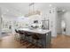 Open concept kitchen features an island with bar seating, stainless steel appliances, and custom white cabinetry at 3707 Smoke Hickory Ln, Valrico, FL 33596