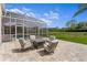 Outdoor patio features a screened enclosure, beautiful pavers, and comfortable seating near the pool and grassy yard at 3707 Smoke Hickory Ln, Valrico, FL 33596
