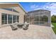 Beautiful rear patio with screened enclosure over pool, comfortable seating, and great views of the well-maintained lawn at 3707 Smoke Hickory Ln, Valrico, FL 33596