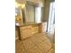 Bathroom featuring a vanity with a mirror, wood cabinetry, and neutral tiled floors at 4111 W La Salle St, Tampa, FL 33607