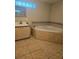 A tiled bathroom featuring a bathtub and vanity with neutral finishes at 4111 W La Salle St, Tampa, FL 33607