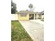 Charming single-story home with a large driveway and a yellow exterior with white trim and ample parking at 4111 W La Salle St, Tampa, FL 33607