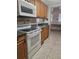 Kitchen featuring appliances, wood cabinets, and dark countertops for a functional cooking space at 4111 W La Salle St, Tampa, FL 33607