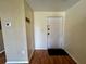 Entryway with hardwood floors, a thermostat, coat rack, and a white front door at 4215 E Bay Dr # 1707C, Clearwater, FL 33764