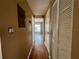 Hallway with wood floors leading to a bright room with a window and closets at 4215 E Bay Dr # 1707C, Clearwater, FL 33764