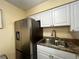 Well-lit kitchen featuring stainless steel refrigerator and sink, paired with modern cabinets and countertops at 4215 E Bay Dr # 1707C, Clearwater, FL 33764