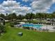 A beautiful pool with plenty of seating overlooks lush landscaping and a clear blue sky with fluffy clouds at 4215 E Bay Dr # 1707C, Clearwater, FL 33764