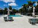 Community pool with several seating options, including lounge chairs and tables with chairs, shaded by umbrellas at 4215 E Bay Dr # 1707C, Clearwater, FL 33764