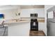Bright kitchen featuring white cabinets, modern appliances, neutral countertops, and wood flooring at 4221 W Spruce St # 1429, Tampa, FL 33607