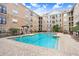 Community pool with stone tile surround, lounge chairs, and well-manicured landscaping at 4221 W Spruce St # 1429, Tampa, FL 33607