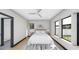Bright bedroom featuring large windows, ceiling fan, light wood floors, and neutral decor at 4316 Wallace Cir, Tampa, FL 33611