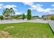 Spacious backyard with a large grassy area, privacy fence, and mature trees, perfect for outdoor activities at 502 Arch Ridge Loop, Seffner, FL 33584