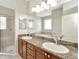 Bright bathroom features double sinks with granite countertop, tiled shower, tub, and a large mirror at 502 Arch Ridge Loop, Seffner, FL 33584