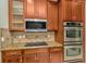 Modern kitchen featuring stainless steel appliances, granite countertops, and wood cabinets at 502 Arch Ridge Loop, Seffner, FL 33584