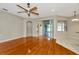 Living room with hardwood floors and ceiling fan with view into sunroom through sliding glass doors at 502 Arch Ridge Loop, Seffner, FL 33584