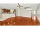 Open living room featuring a kitchen with granite countertops, ceiling fan, and access to front door at 502 Arch Ridge Loop, Seffner, FL 33584