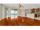 Open living room and kitchen area with hardwood floors, ceiling fan, and access to the screened-in porch at 502 Arch Ridge Loop, Seffner, FL 33584