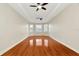 Living room featuring hardwood floors, tray ceilings with two ceiling fans, and bright, natural light at 502 Arch Ridge Loop, Seffner, FL 33584