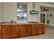 Outdoor kitchen featuring granite countertops, wooden cabinets, and stainless steel hood for premium outdoor cooking at 502 Arch Ridge Loop, Seffner, FL 33584