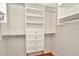 This walk-in closet features custom built-in shelving and drawers to maximize storage space at 502 Arch Ridge Loop, Seffner, FL 33584