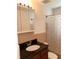 Bathroom featuring vanity with black countertop and tiled shower/tub with patterned curtain at 6081 22Nd N Ave, St Petersburg, FL 33710