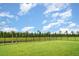 Expansive backyard featuring lush green lawn and secure black fencing with serene lake views at 6226 165Th E Dr, Parrish, FL 34219