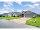 View of single-story home with grey siding, a well-manicured lawn, and a two-car garage at 6226 165Th E Dr, Parrish, FL 34219