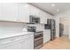 This kitchen has stainless steel appliances, white cabinets, and stone countertops at 6226 165Th E Dr, Parrish, FL 34219